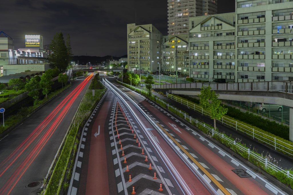 夜の都市を走る車の光跡と道路