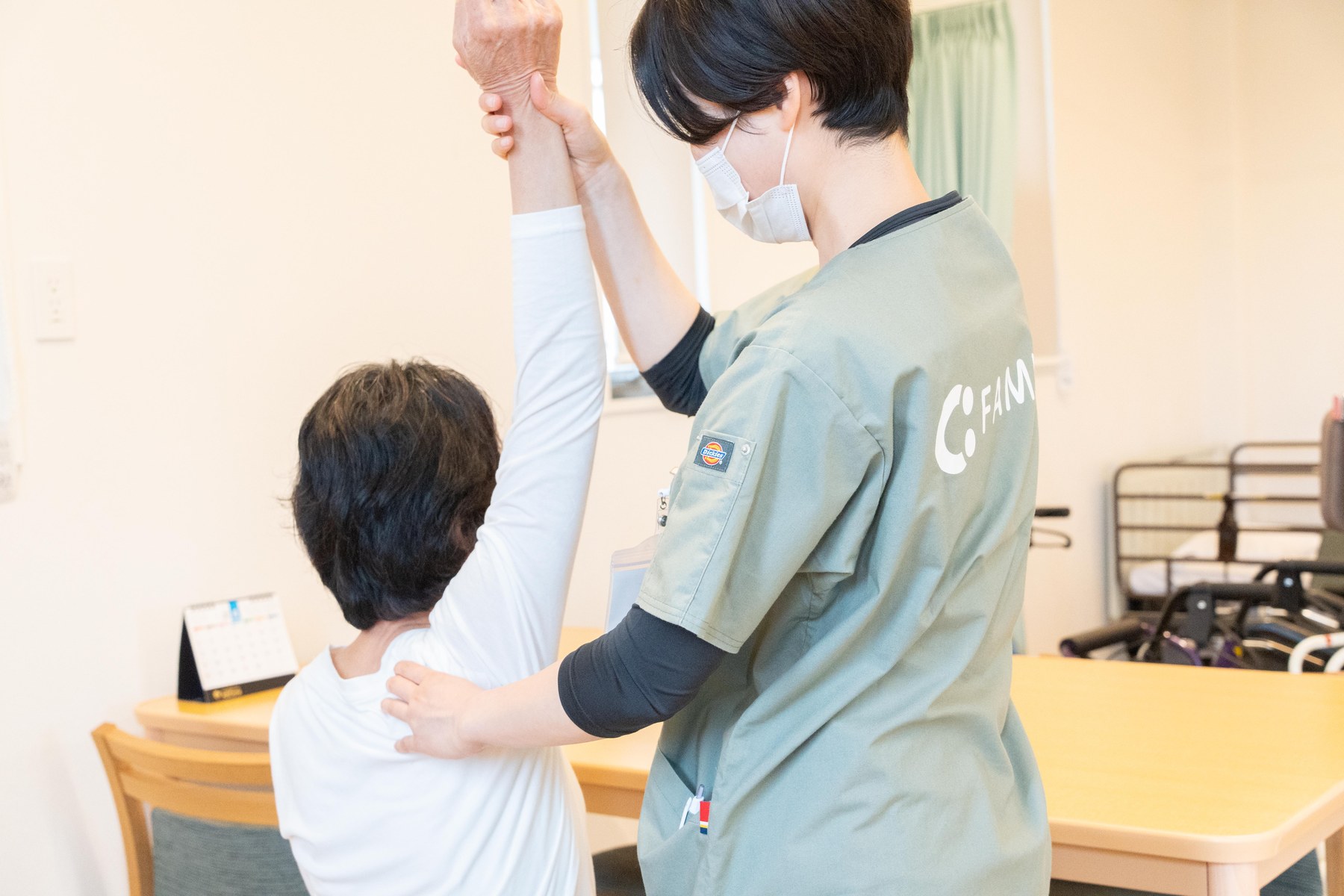 ReHanaでスタッフが利用者の腕の動きを支援する場面
