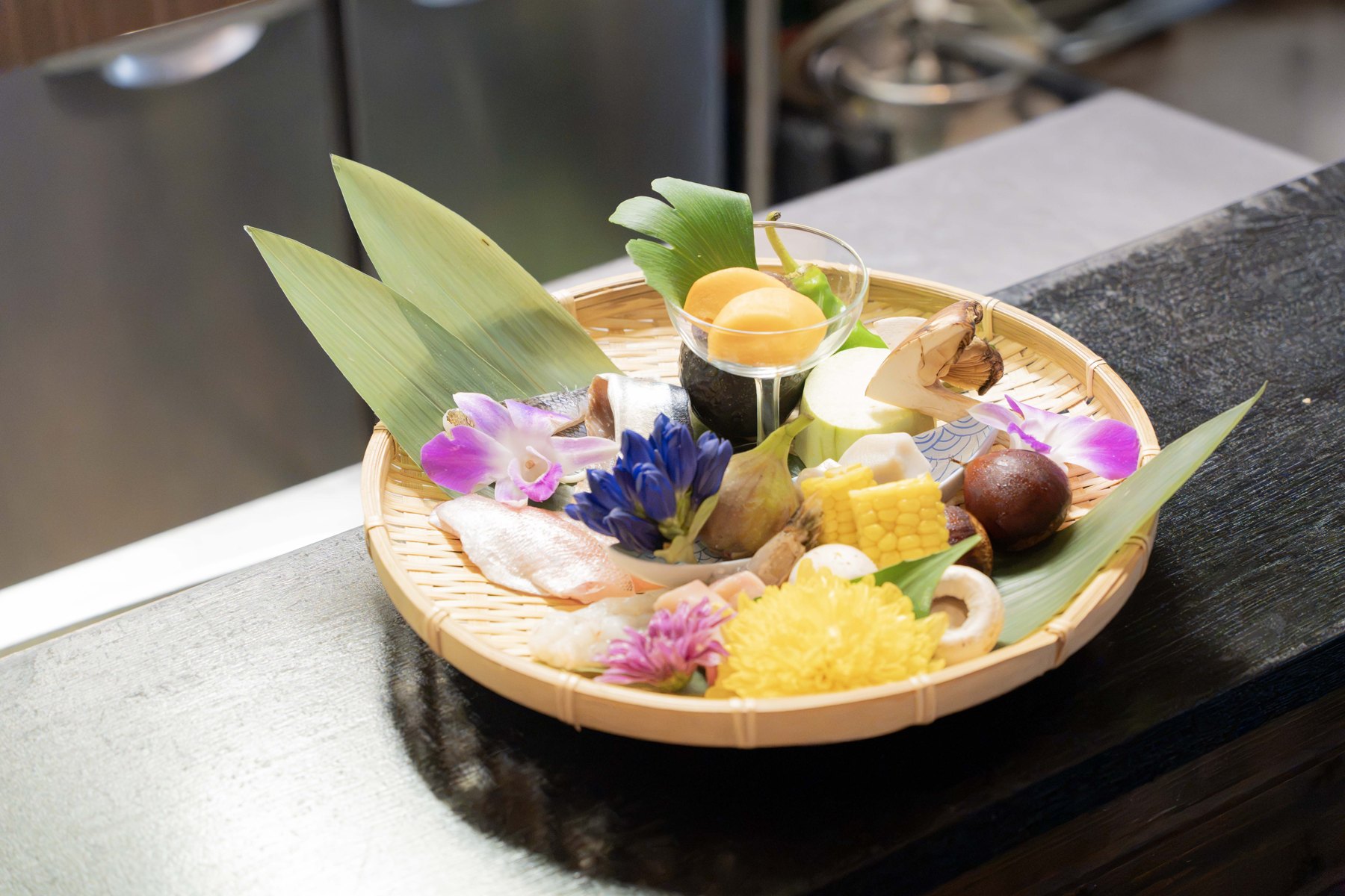 天ぷら さくの野菜や魚などの食材を盛り合わせた竹ざる